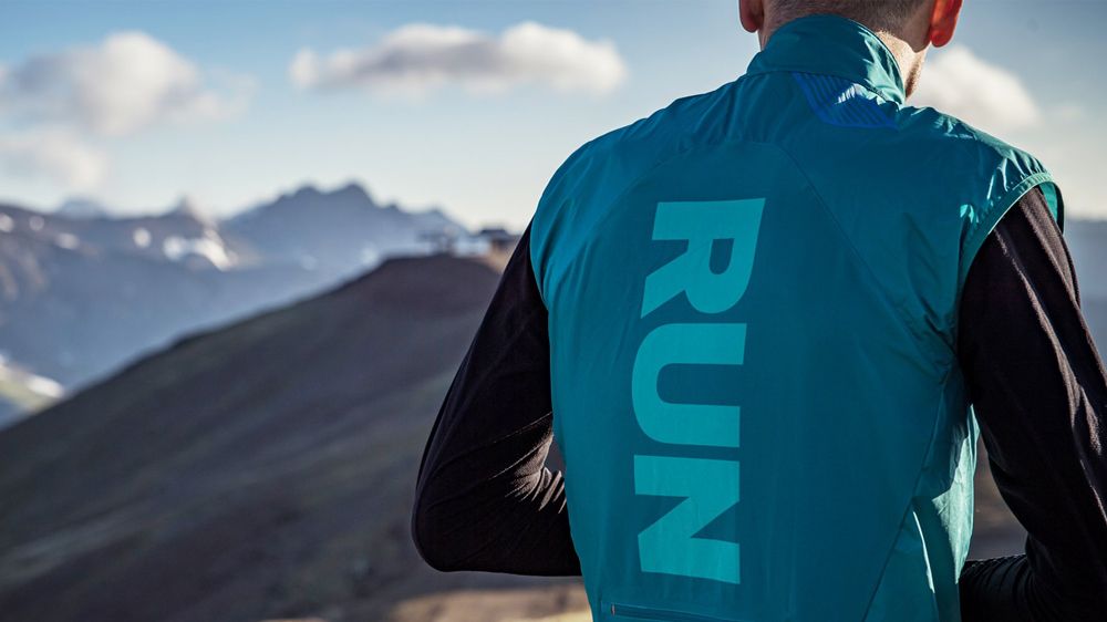 Rear view of Soar Running Gilet worn by man, mountains in background