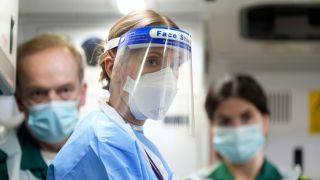 Dr. Abbey Henderson (Joanne Froggatt), decked out in scrubs and full PPE, flanked by two fellow doctors in Breathtaking