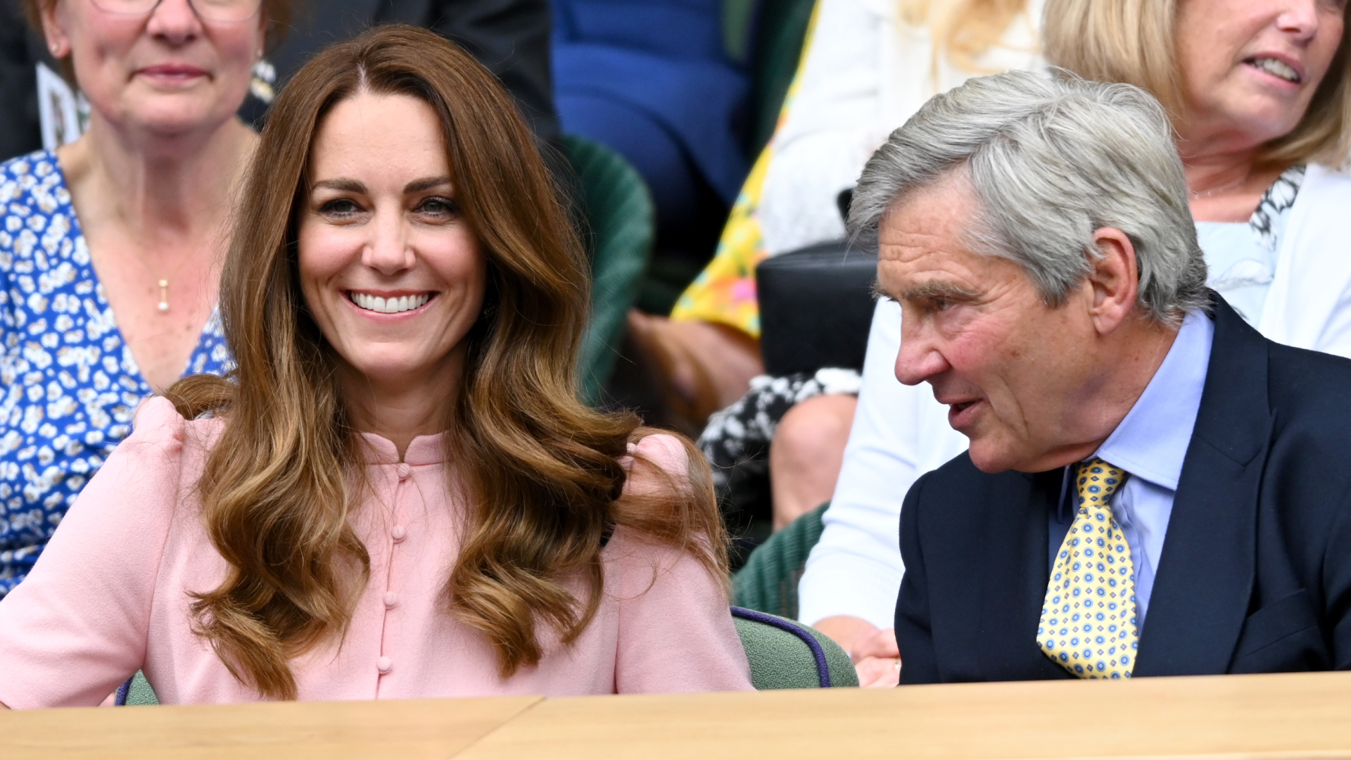 Kate Middleton wears a pink shirt dress and has long brown wavy hair attending Wimbledon with her dad Michael Middleton