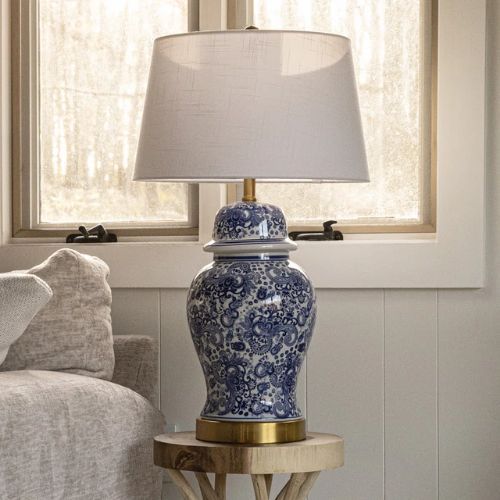 Blue, white and gold ceramic table lamp on wooden table