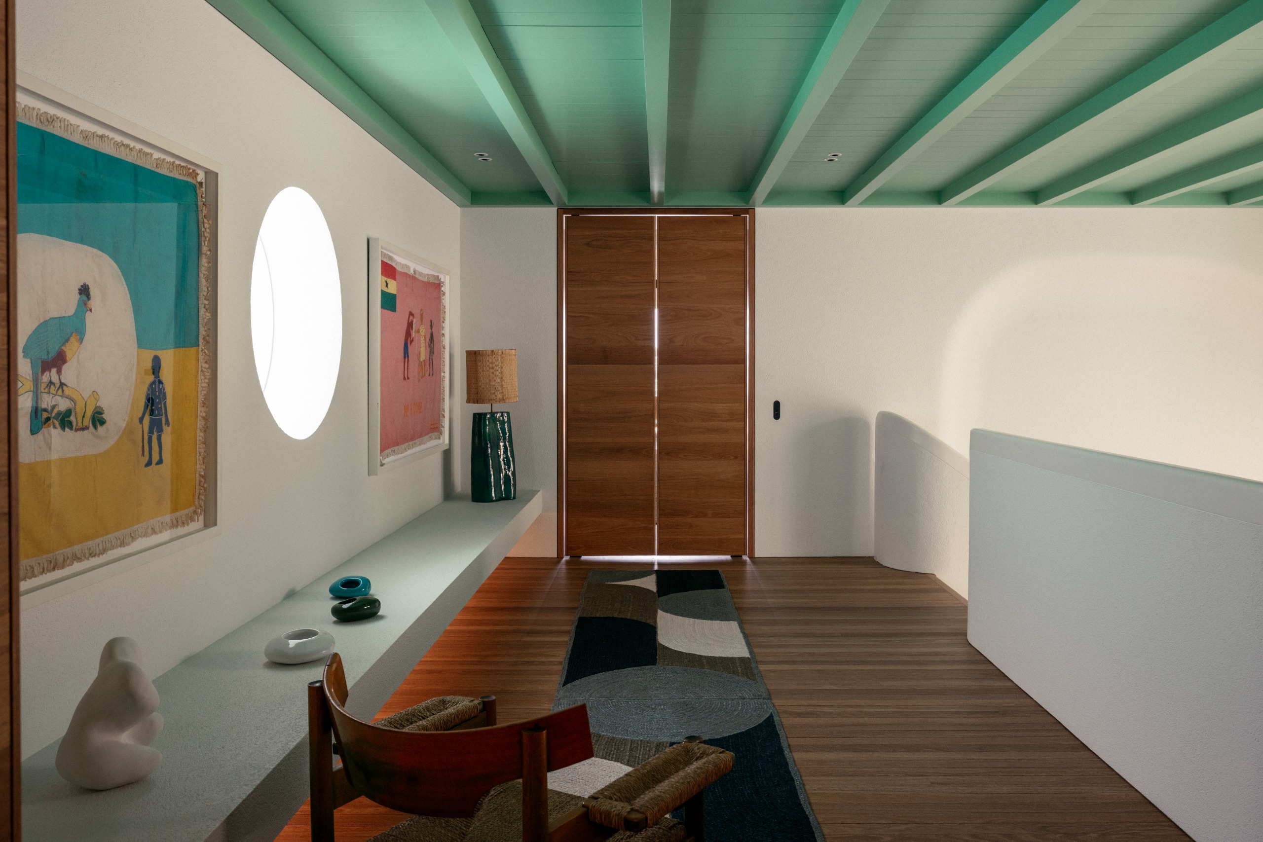 landing in a home with timber built-in bookcase, runner, armchair, and painted mint green ceiling with exposed beams