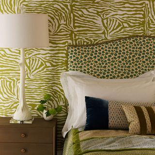 bedroom with green animal print wall bed with designed cushion and white lamp