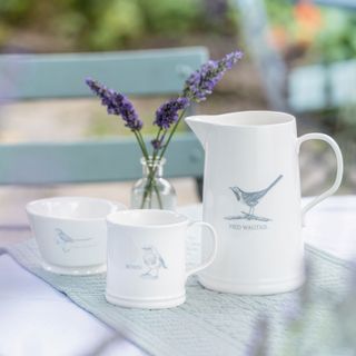 a bowl mug and jug decorated with bird patterns