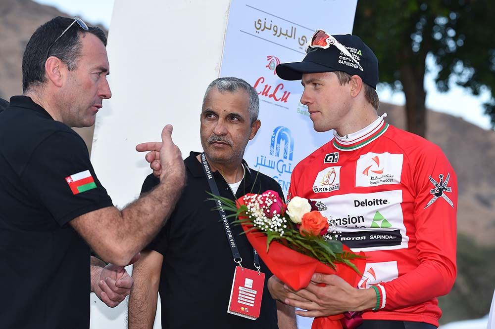 Edvald Boasson (Dimension Data) talks on the podium after pulling on the red jersey.