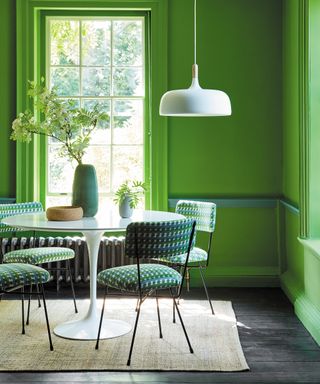 Decorating small spaces with a fully green color scheme, shown in a dining room with round table and chairs.