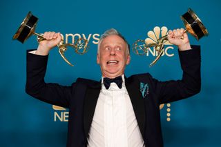 The White Lotus creator Mike White posing with two Emmy Awards