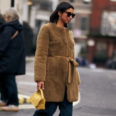 a woman wearing a furry winter coat in street style