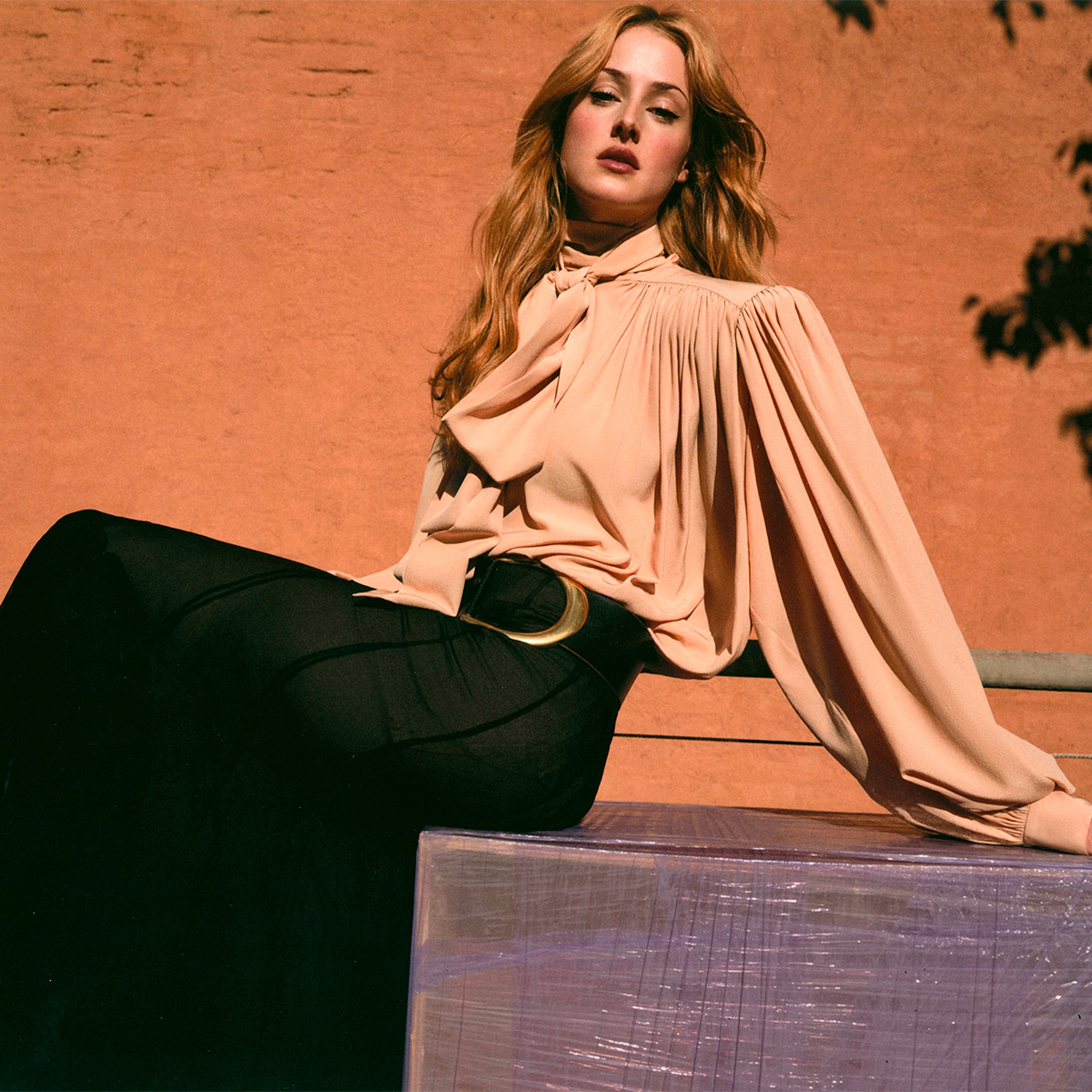 Anna van patten wears a peach-colored blouse and a black skirt.