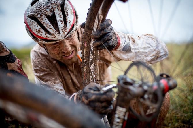 Christoph Sauser of Meerendal Songo Specialized trying to fix a mechanical during stage 2