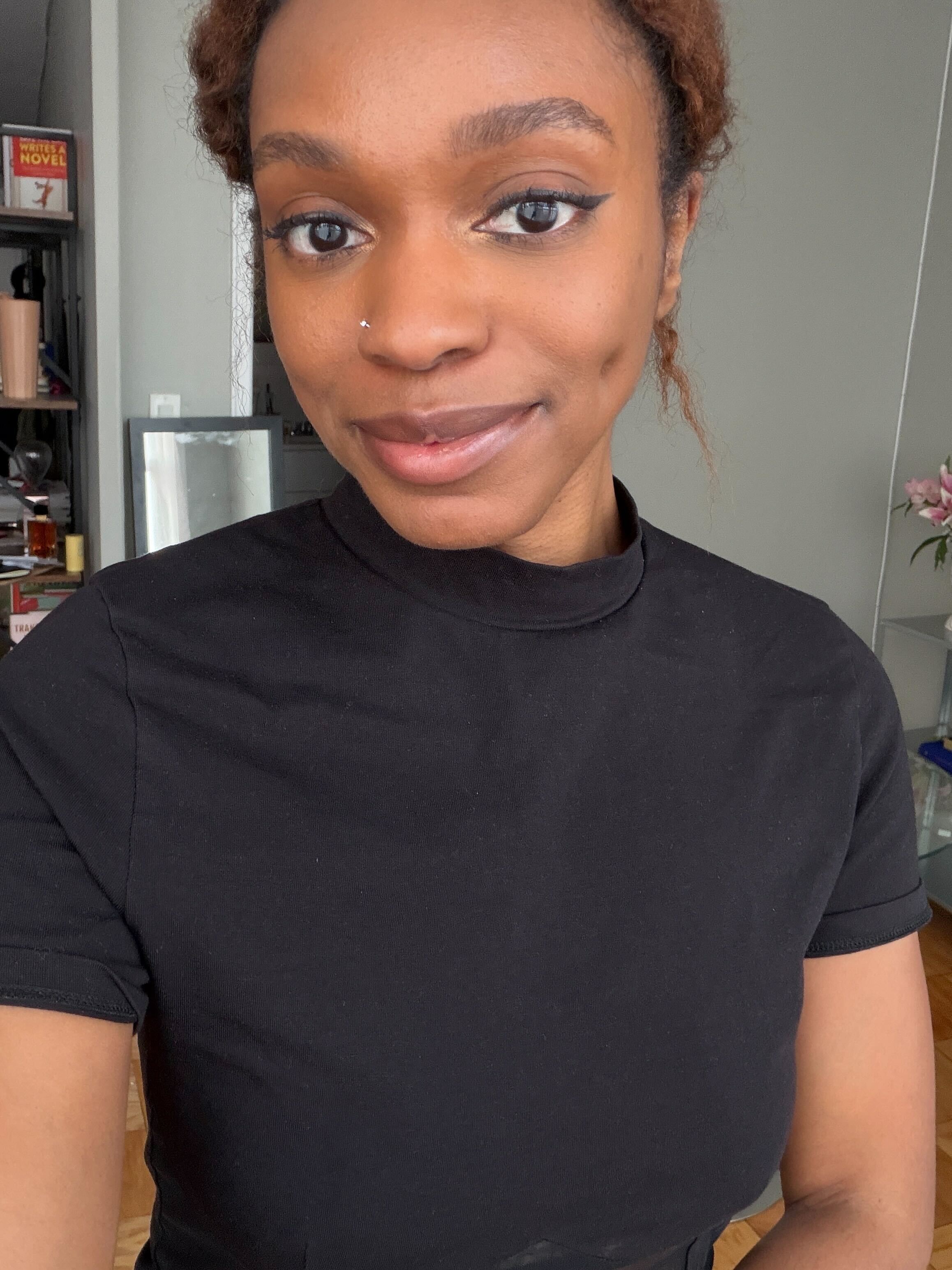 a woman in a black turtleneck t shirt with her hair in a bun