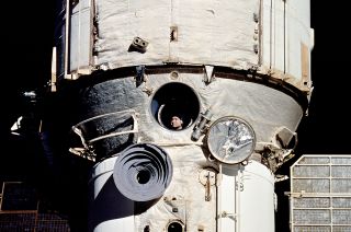 Cosmonaut Valery Polyakov, who was more than a year into his record-breaking 438-day mission, looks out the window of Russia's Mir space station during rendezvous operations with the space shuttle Discovery during the STS-63 mission in 1995.