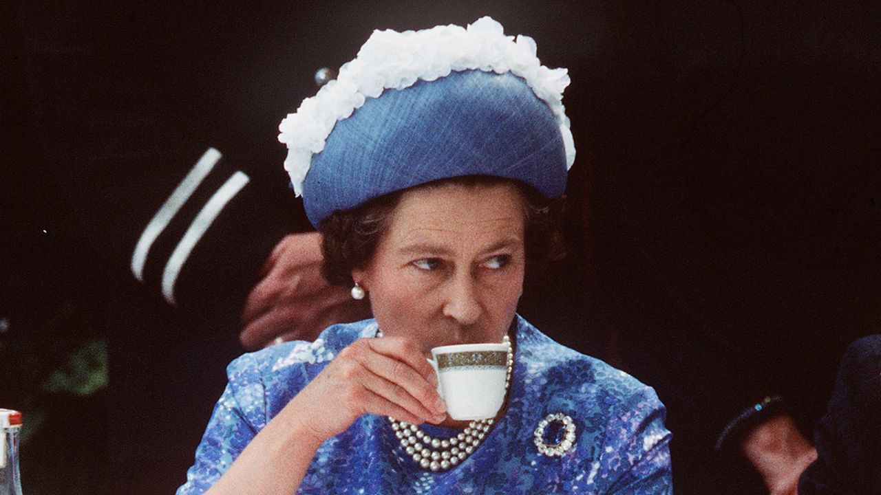 Camilla Parker Bowles&#039;s son Tom has shared the secret to making the Queen a perfect cup of tea. NORTHERN IRELAND - 1977: Queen Elizabeth ll has a cup of tea while in Northern Ireland on a royal visit in 1977.(Photo by Anwar Hussein/Getty Images)