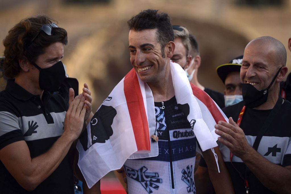 Team Qhubeka Nexthashs Italian rider Fabio Aru C is applauded by teammates after riding the 21st and final stage of the 2021 La Vuelta cycling tour of Spain a 338 km timetrial race from Padron to Santiago de Compostela on September 5 2021 Photo by MIGUEL RIOPA AFP Photo by MIGUEL RIOPAAFP via Getty Images