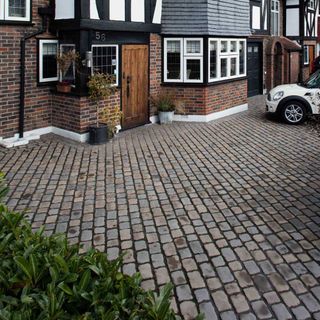 Cobblestone driveway outside a mock tudor home
