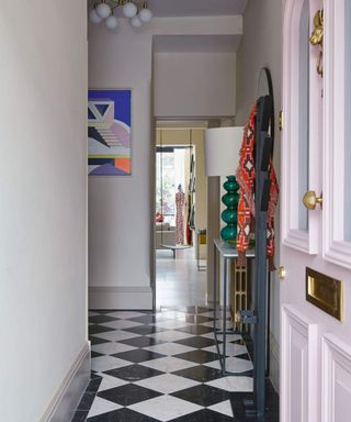 A front door opening onto a hallway, complete with checkerboard floor tiles