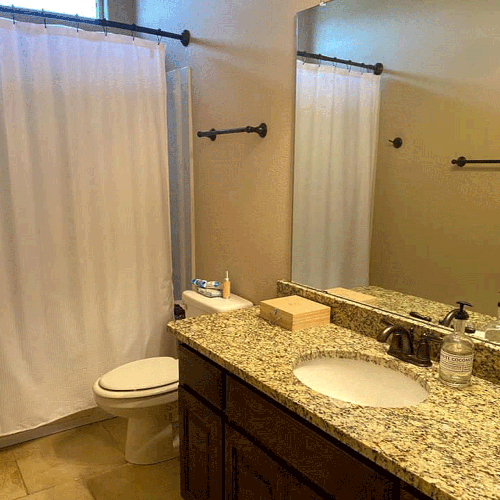 bathroom with white wall and washbasin and curtain and towel rail