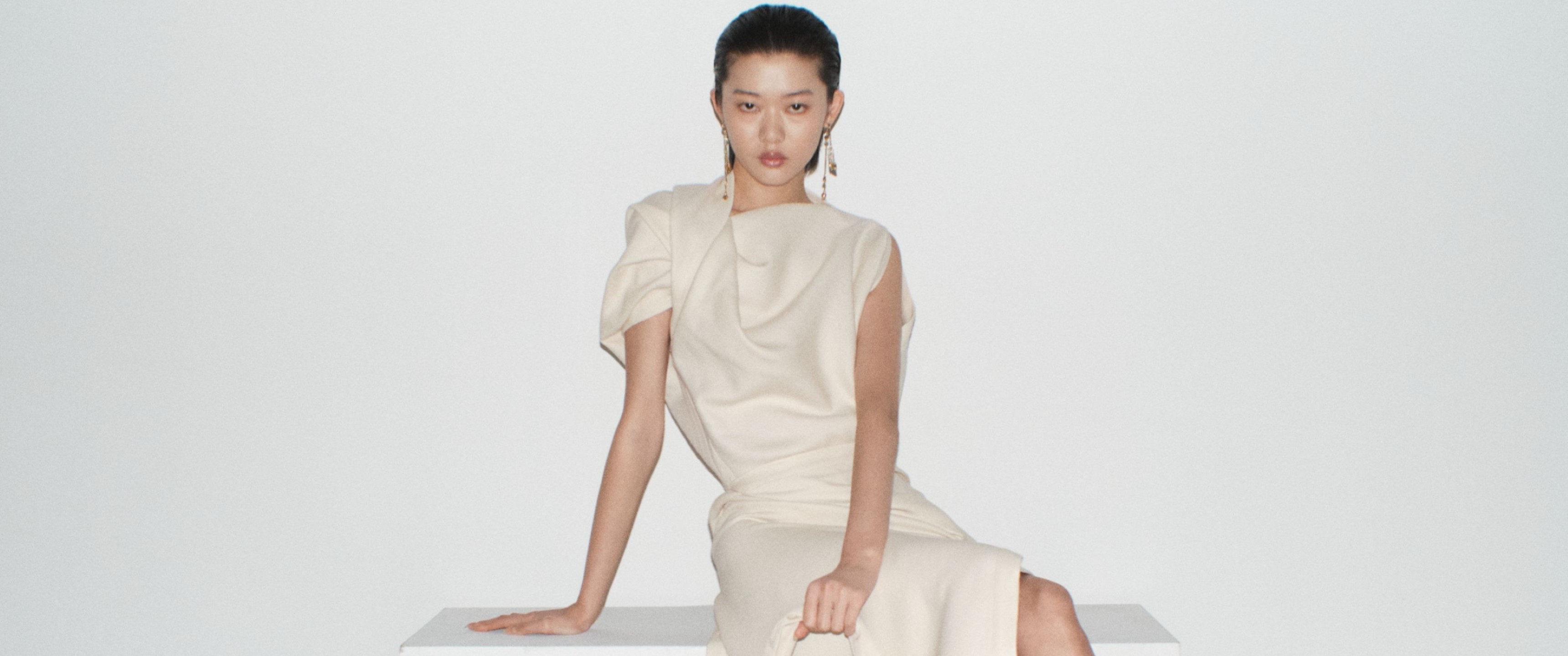 Model in an off-white dress sold at SSENSE