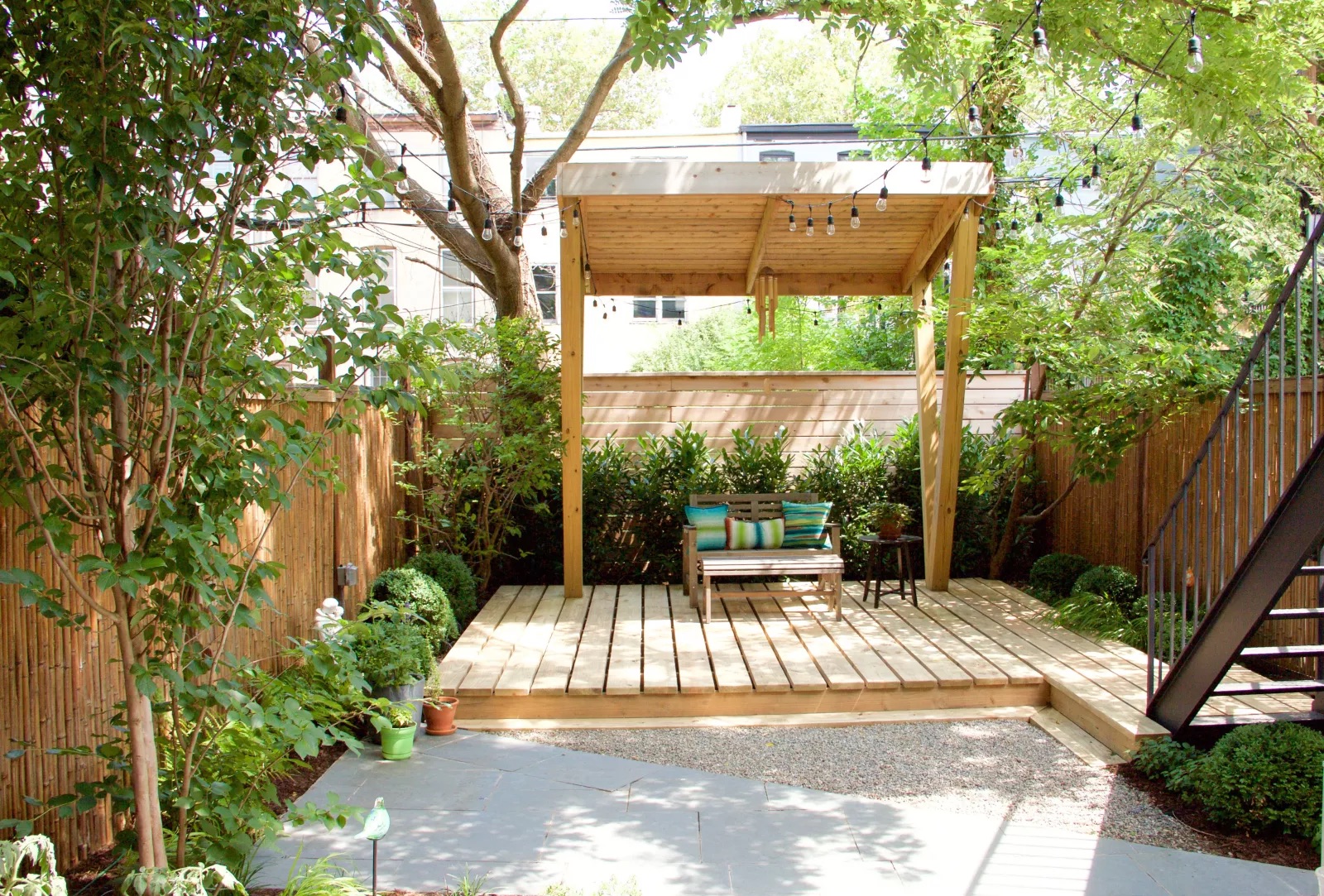A sheltered deck area at the end of the garden with seating and string lights