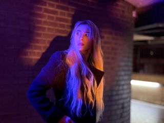 Model in front of brick wall lit with a red and blue light