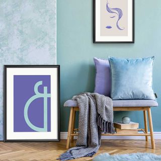 blue wall, artwork and cushions on a small side table