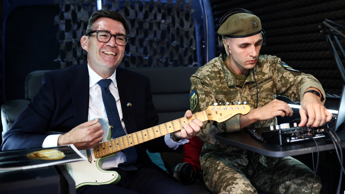 Andy Burnham (L) plays the guitar in the mobile recording studio of the military and artistic unit, on August 24, 2026 in Kyiv, Ukraine.