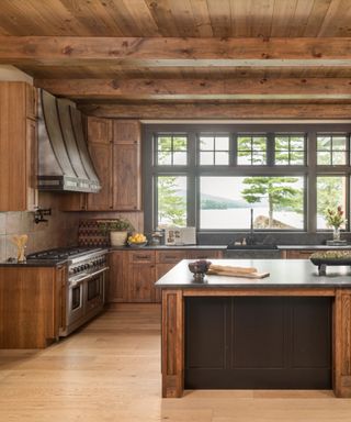 wood kitchen with wooden ceiling, cabinets, floor, brown kitchen island, dark gray countertop, large range cooker,