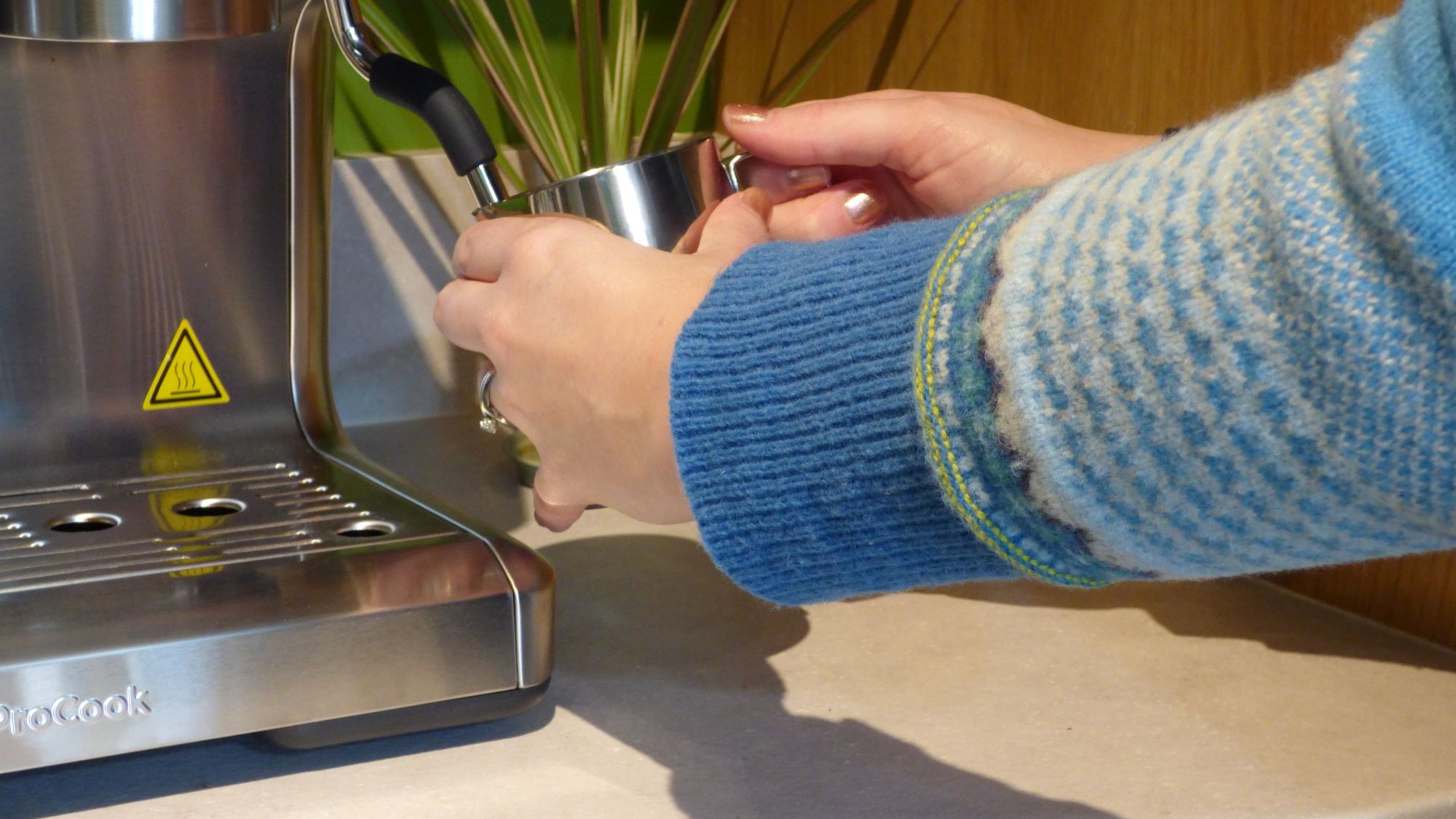 Person steaming milk using ProCook Bean To Cup Espresso Coffee Machine