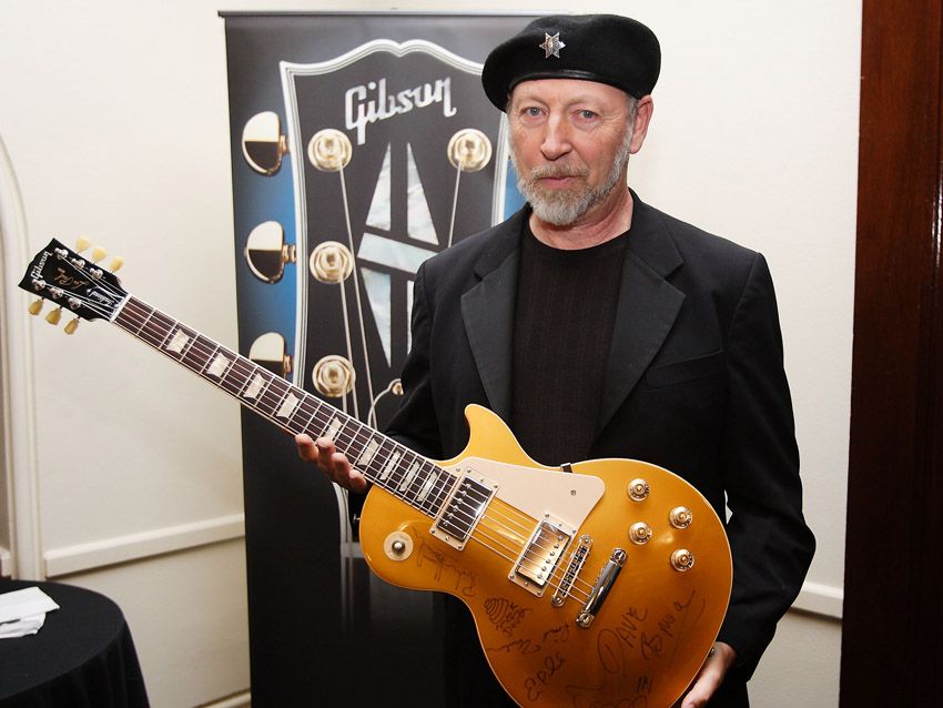 The Les Paul Award winner holds the signed axe.
