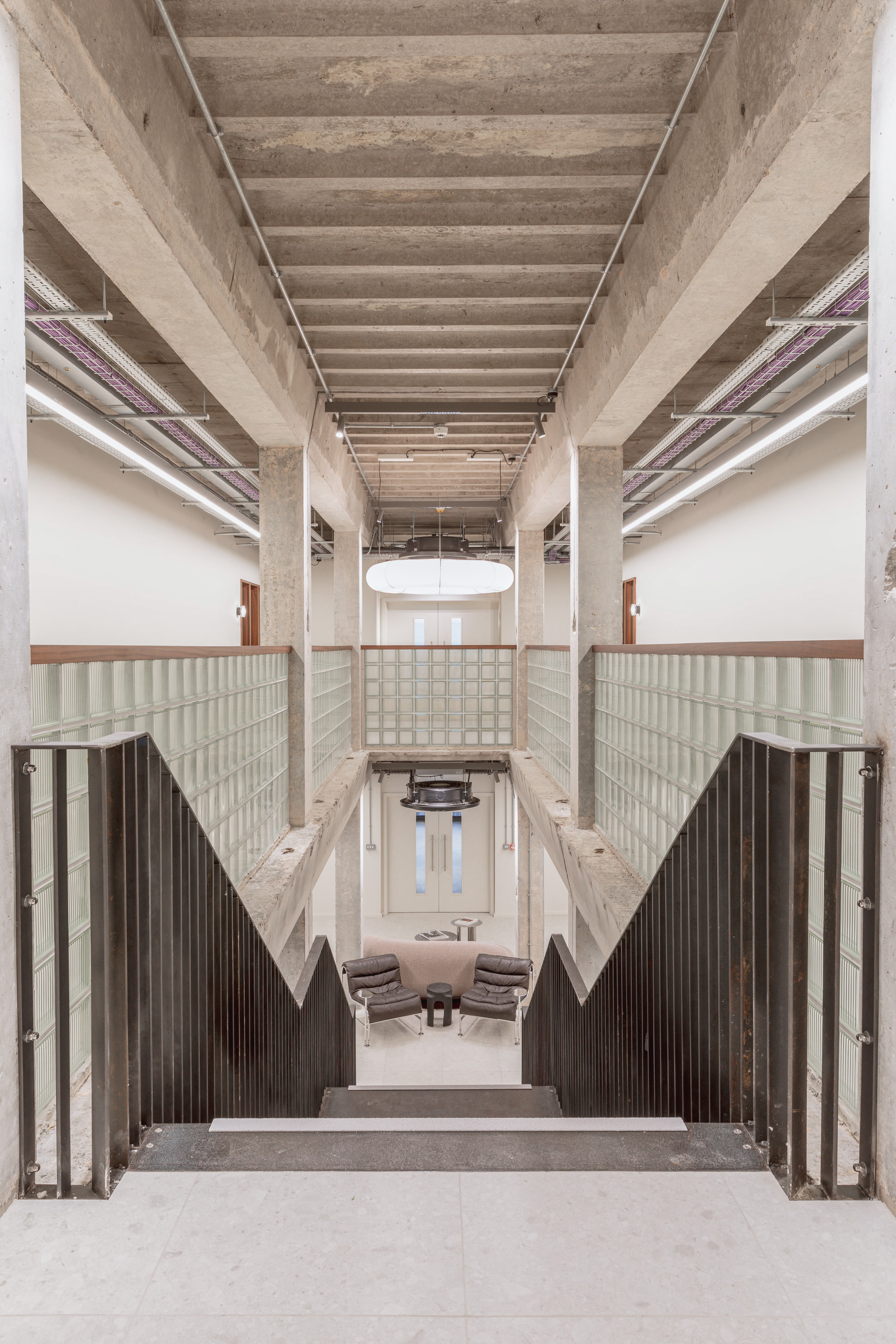 View from the top of a staircase in an industrial concrete office interior
