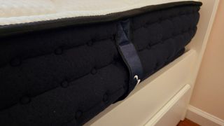 A closeup of the side of the DreamCloud Hybrid Mattress, one week after setup the border is still bulging, indicating the mattress has not fully expanded yet