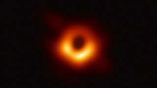 The first ever direct image of a black hole, with yellow ring surrounding black circle