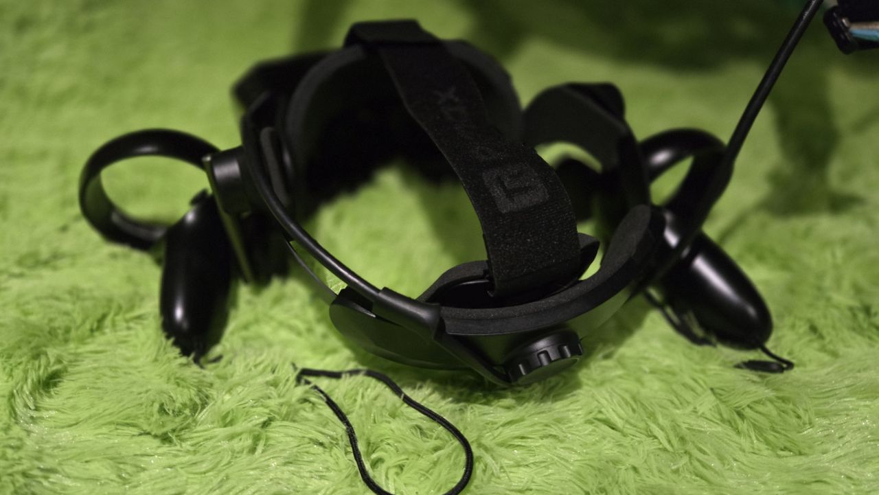 A Pimax Crystal Super virtual reality headset on a green background.