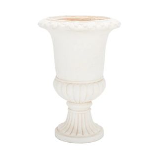 A white resin urn with distressed paint on it