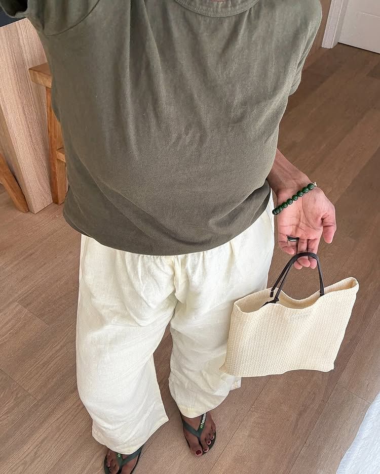 @monikh wears an olive top, matching sandals and cream, trousers