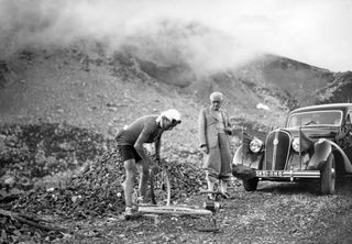 Belgian rider Sylvere Maes repairs his bike after a puncture in the Col du Galibier as Tour de France director Frenchman Henri Desgrange watches him on July 27 1939 during the first leg BrianonBonneval sur Arc of the 16th stage of the Tour de France between Brianon and Annecy Three years after his first victory Maes won his second Tour de France AFP PHOTO Photo by AFP Photo by AFP via Getty Images