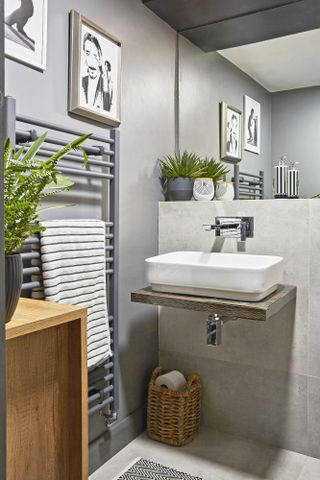 Grey bathroom with stone-effect tiles, wall-hung sink and grey towel rail