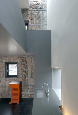 Interior section of the kitchen, featuring grey designs and a silver tap