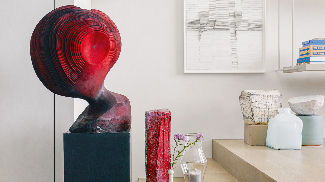 Large red abstract sculpture on a black plinth