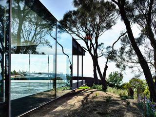 Side of glass villa with view of trees