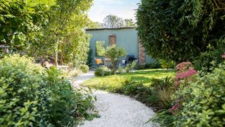 landscaped garden with stone path and shrub borders planted with gardening tips for beginners