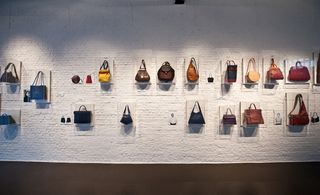 A timeline of bags lines a wall