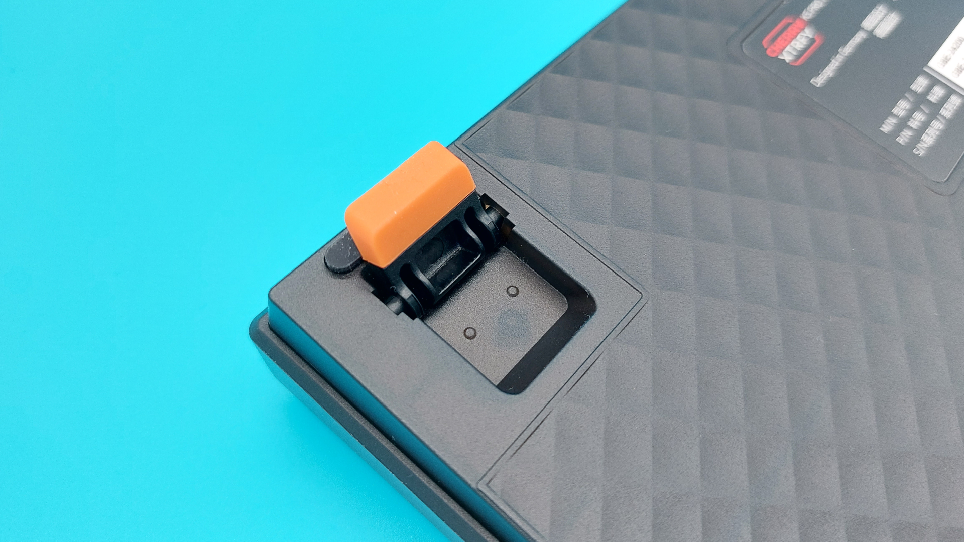 The Cherry K5 Pro TMR Compact seen from the back, with the orange feet flipped out to prop up the gaming keyboard.