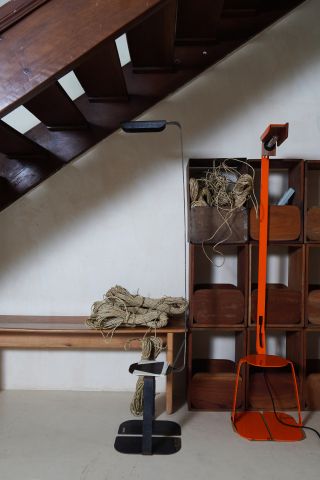 Inside a studio with a table, set of shelves, rope and other fittings.