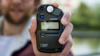 Man holding Sekonic Flashmate L-308X light meter