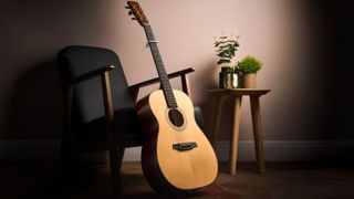 Martin acoustic guitar with capo against a chair