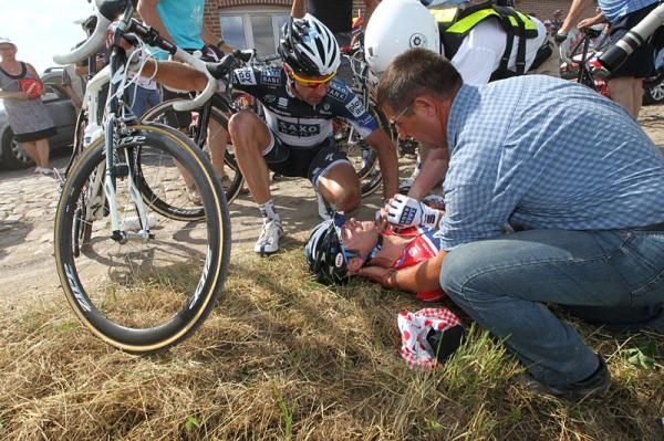 Jens Voigt stops to check on Frank Schleck, who abandoned the Tour with a broken collarbone after falling on the cobbled sector.