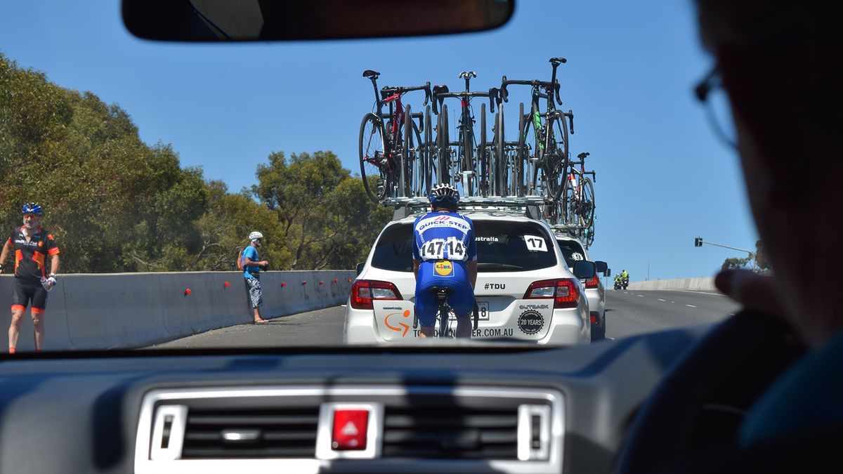 Enric Mas of Quick-Step Floors works his way through the team cars to rejoin the bunch
