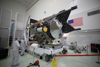 Technicians work on NASA's Psyche spacecraft inside a clean room.