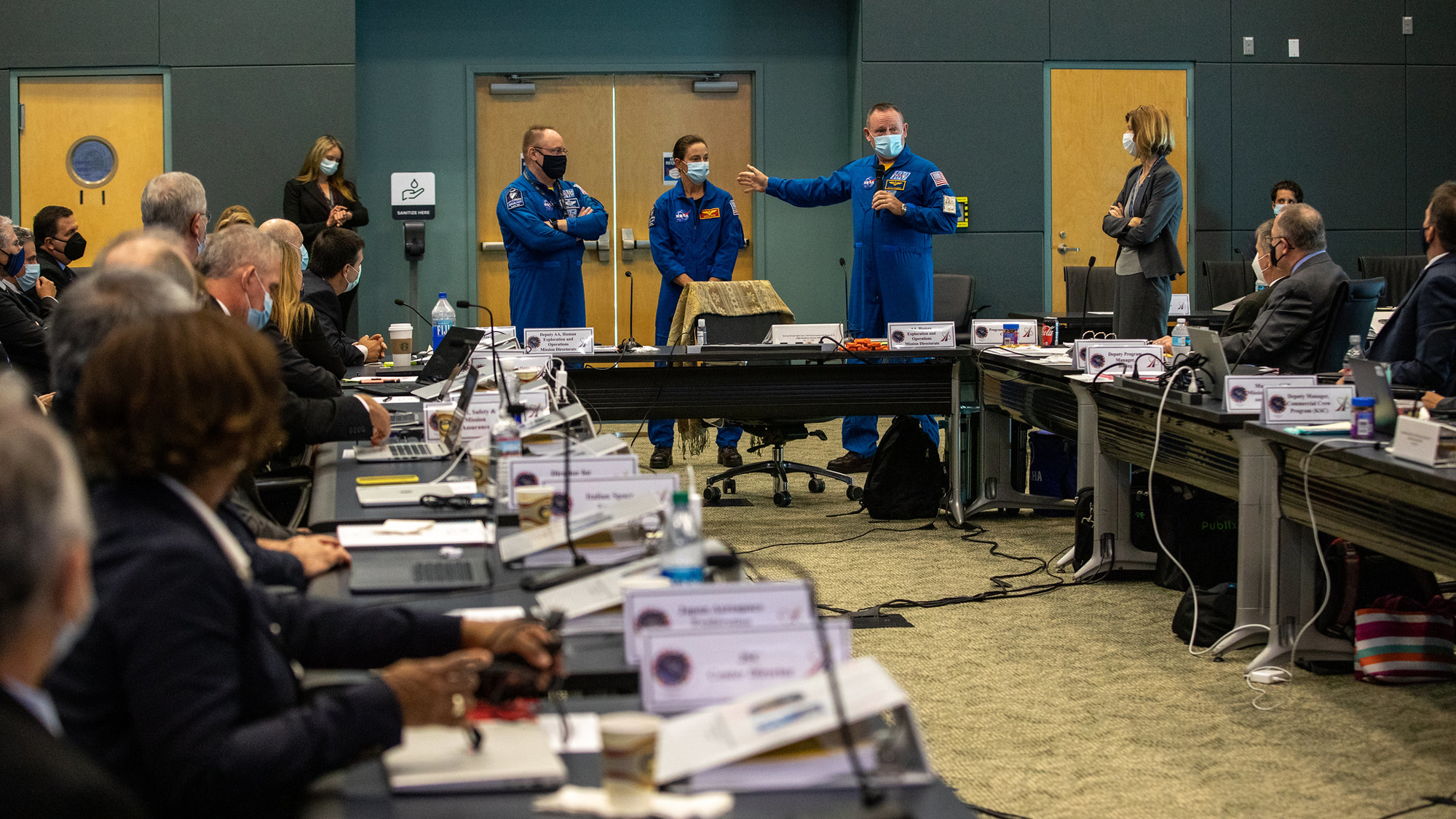 Come parte di una revisione della prontezza di volo per l'Orbital Flight Test-2 (OFT-2) di Boeing, gli astronauti della NASA per testare il Boeing Crew Flight Test (CFT), il comandante Barry "Butch" Willmore, il pilota Nicole Mann e il comandante delle operazioni congiunte E. Michael "Mike" Fincke si rivolge ai manager della NASA e della Boeing presso l'Operations Support Building 2 presso il Kennedy Space Center della NASA in Florida, il 22 luglio 2021.