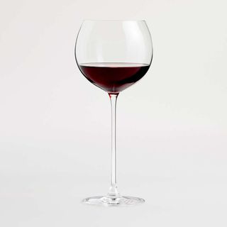 Crate & Barrel Camille Wine Glass against a gray background.